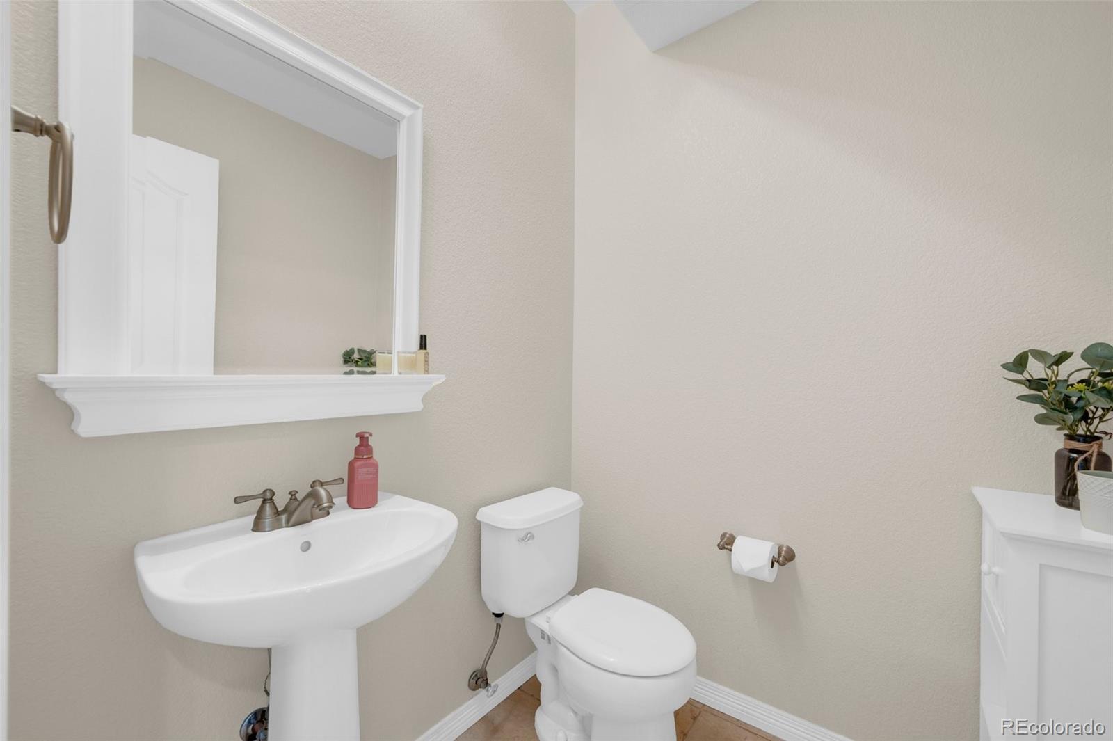 2382 Antelope Ridge Trail Parker, CO 80138 - Photo 33 of 49 a bathroom with a sink a toilet and mirror