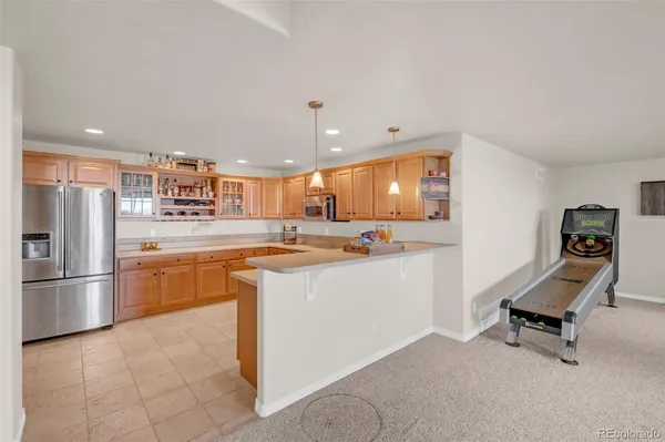 a kitchen with stainless steel appliances kitchen island granite countertop a refrigerator and a stove top oven