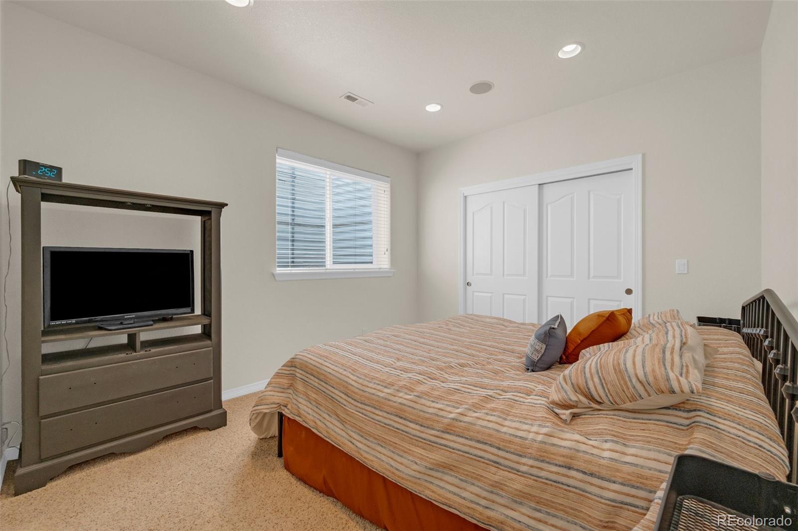 2382 Antelope Ridge Trail Parker, CO 80138 - Photo 42 of 49 a bedroom with a bed and flat screen tv