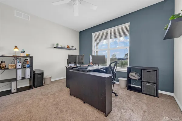 a view of a workspace with furniture and a window