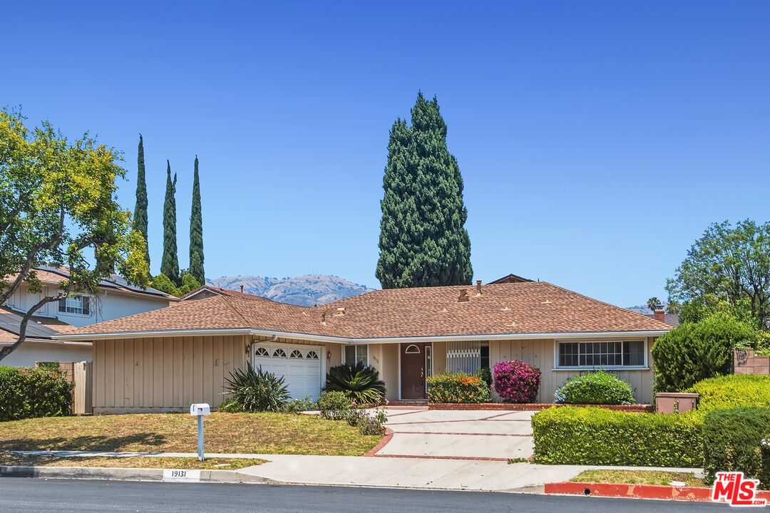 19131 Tulsa Street Porter Ranch, CA 91326 - Photo 3 of 43 a front view of a house with a garden