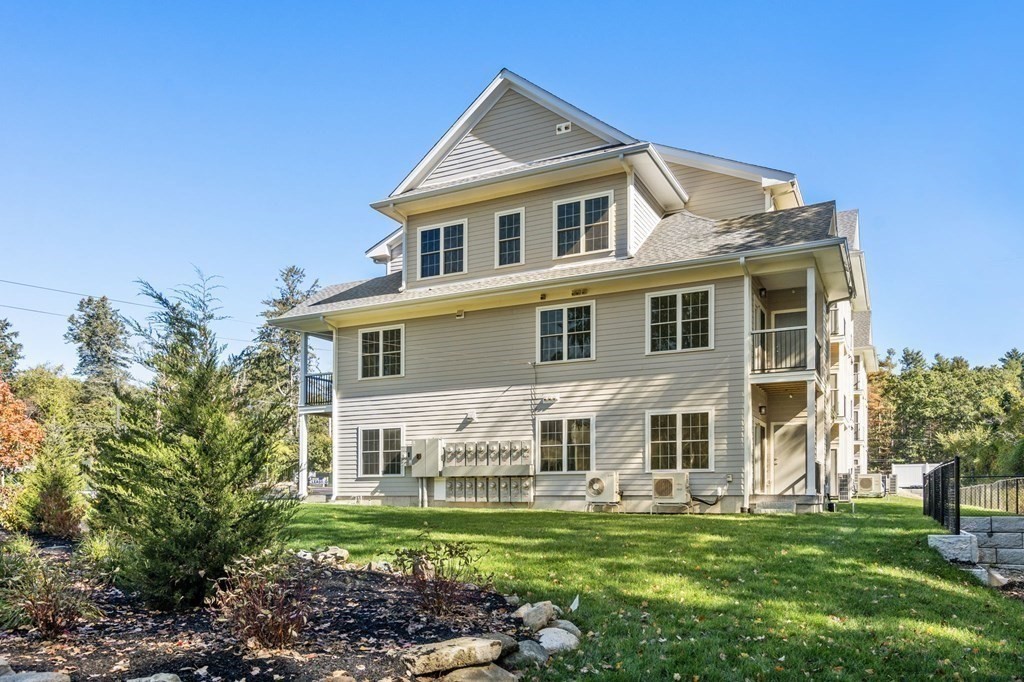 242 Main Street, Unit 302 Millis, MA 02054 - Photo 4 of 18 a front view of a house with a garden