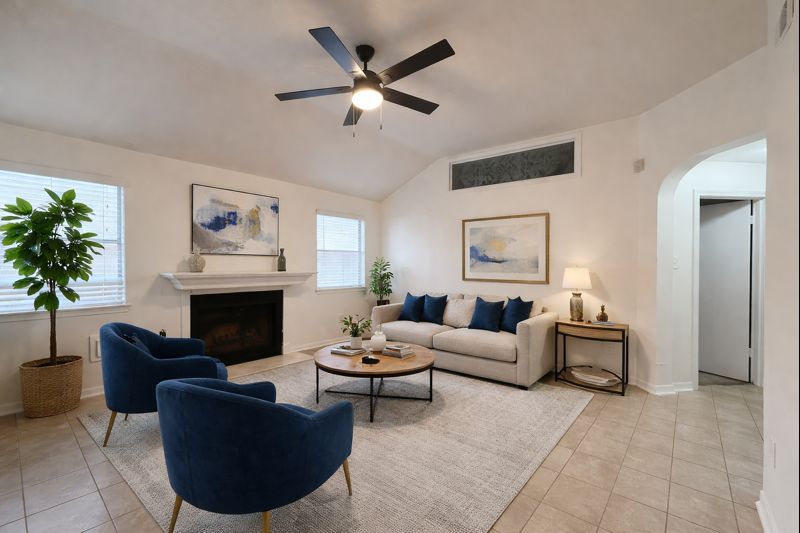 a living room with furniture a fireplace and a potted plant