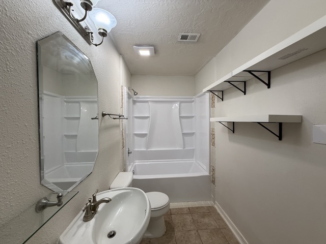 1809 Whitney Way Austin, TX 78741 - Photo 19 of 25 Secondary bathroom is spacious and includes a shower/tub combo, pedestal sink and shelving.