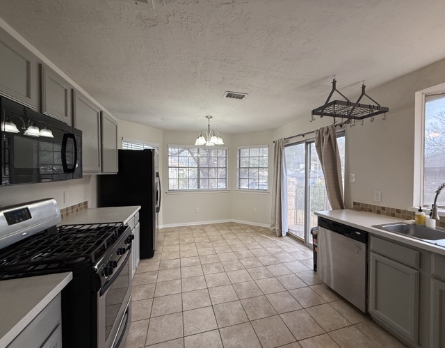 1809 Whitney Way Austin, TX 78741 - Photo 6 of 25 Freshly repainted, including kitchen cabinetry to create a clean and modern aesthetic. Additional features include stainless steel appliances, bay windows, hanging light fixture above the dining area, and sliding glass patio doors extending your living space to the outdoor side yard area.