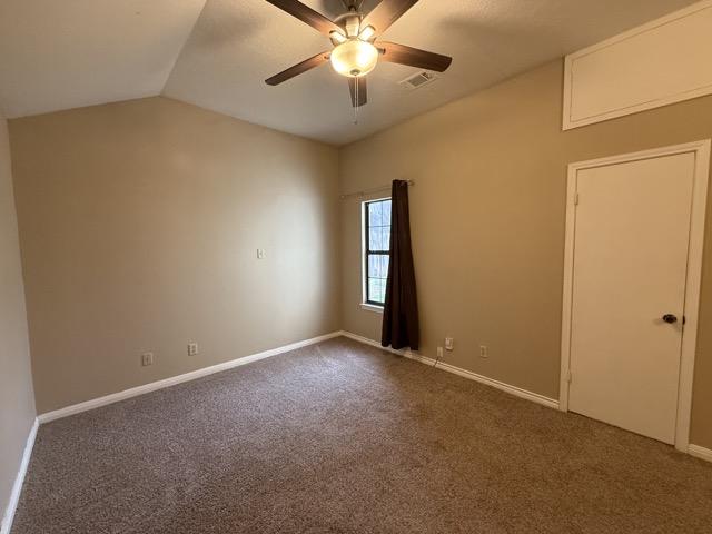 1809 Whitney Way Austin, TX 78741 - Photo 10 of 25 The primary bedroom offers a spacious and private retreat featuring vaulted ceilings, a walk-in closet, and ensuite with a walk-in shower.
