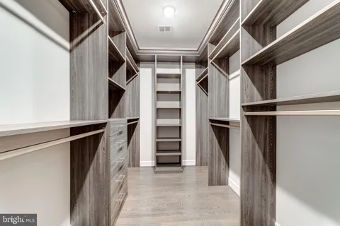 a view of walk in closet with clothes