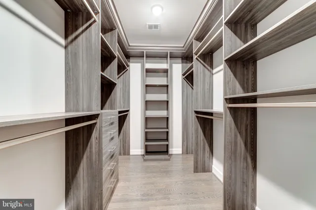 a view of walk in closet with clothes