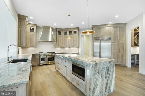 a kitchen with stainless steel appliances granite countertop a stove a sink and a refrigerator