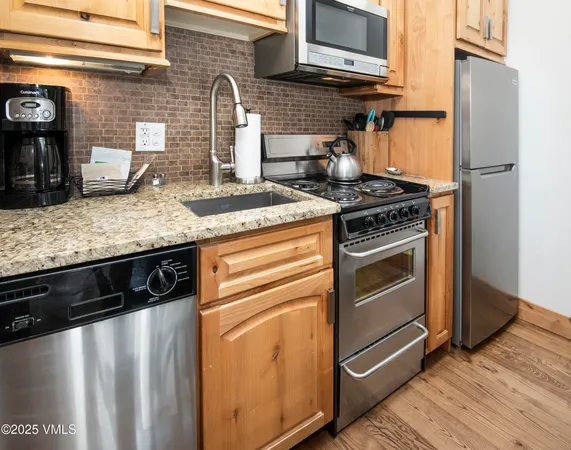 a kitchen with granite countertop a stove and a sink