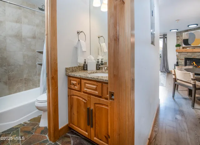 a bathroom with a granite countertop sink a toilet and shower