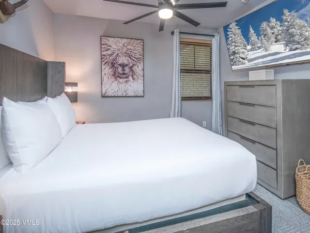 a large bed sitting in a bedroom next to a window