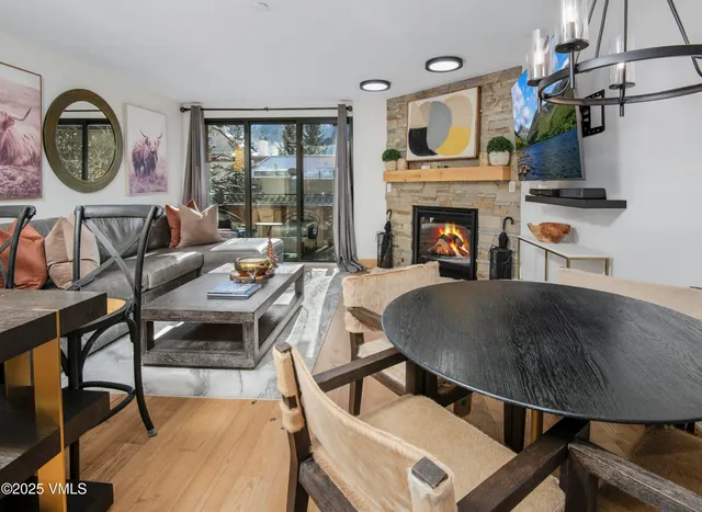 a living room with furniture a fireplace and a floor to ceiling window