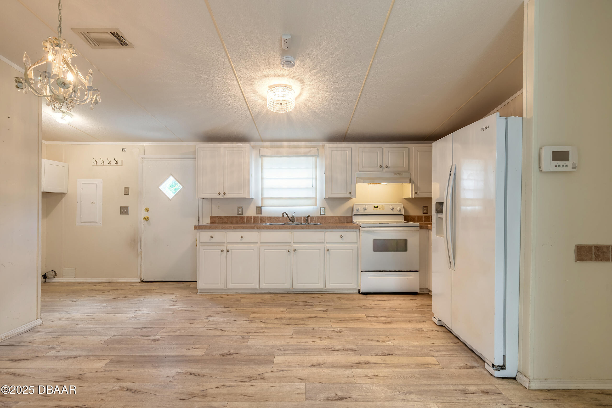 55721 Palmetto Road Astor, FL 32102 - Photo 14 of 27 a kitchen with granite countertop a refrigerator and white cabinets