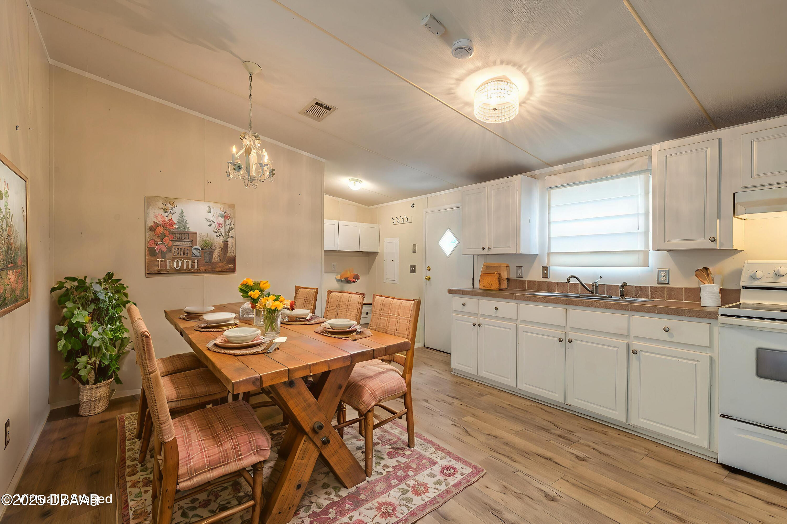 55721 Palmetto Road Astor, FL 32102 - Photo 15 of 27 a kitchen with a dining table chairs sink and cabinets
