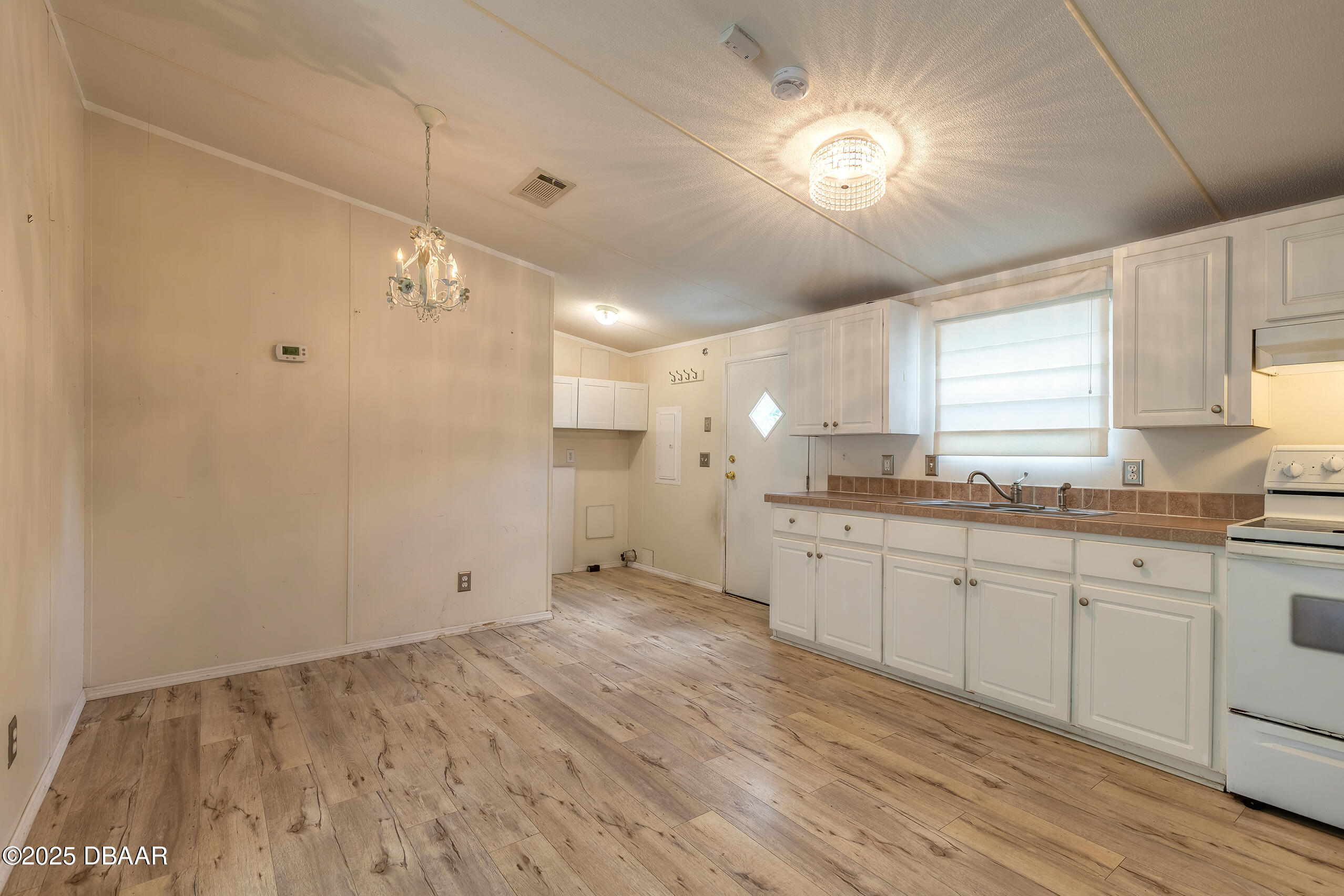 55721 Palmetto Road Astor, FL 32102 - Photo 16 of 27 a large kitchen with chandelier fan and window