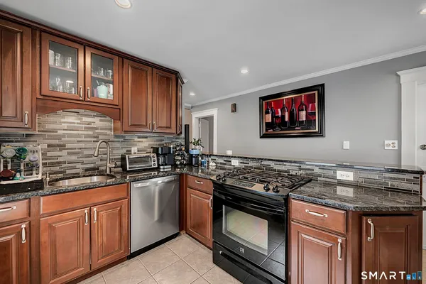 a kitchen with stainless steel appliances granite countertop a stove sink and cabinets