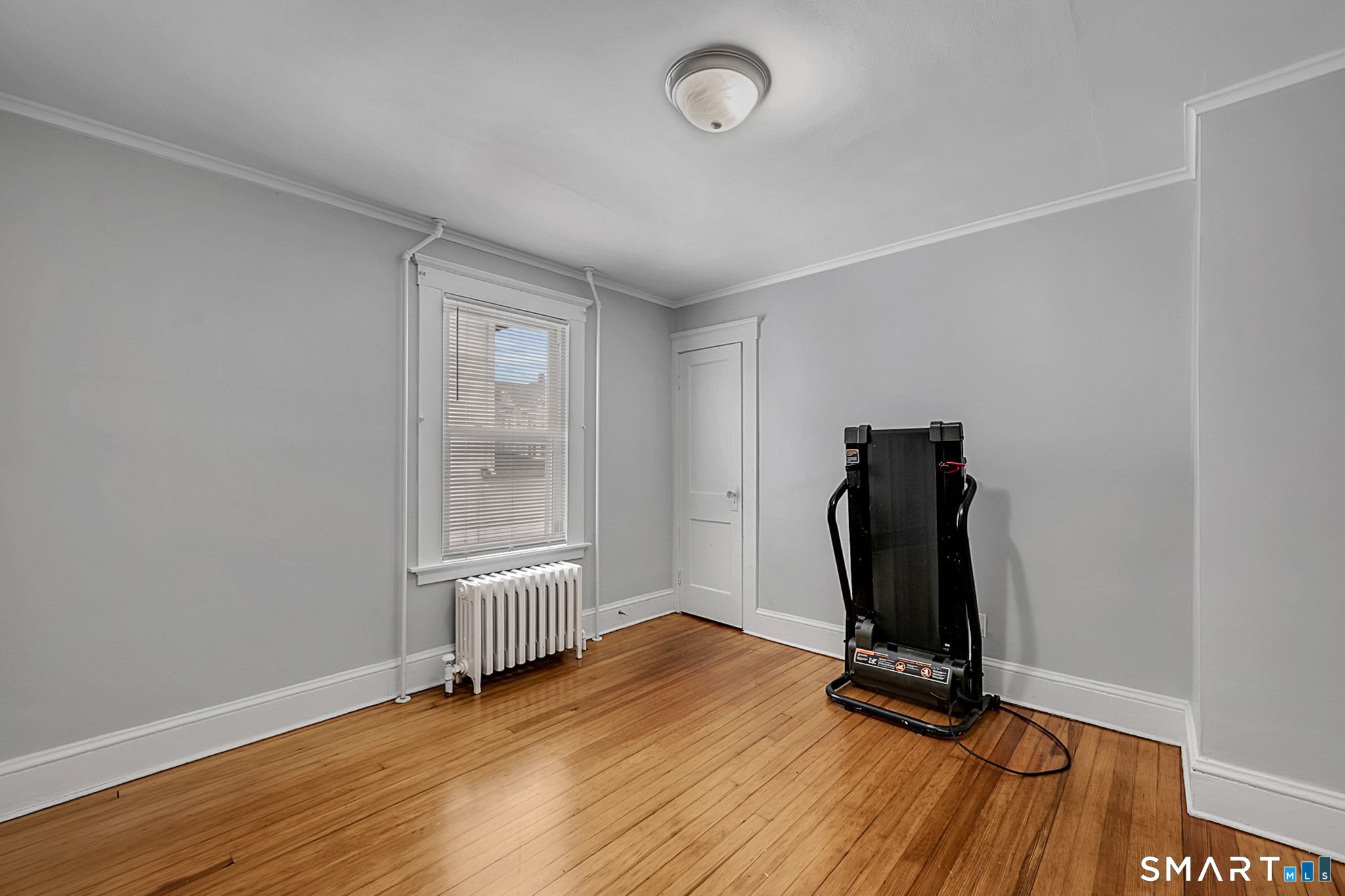64 Cooper Street Torrington, CT 06790 - Photo 23 of 26 an empty room with wooden floor and windows