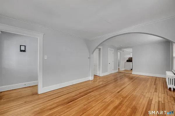a view of empty room with wooden floor