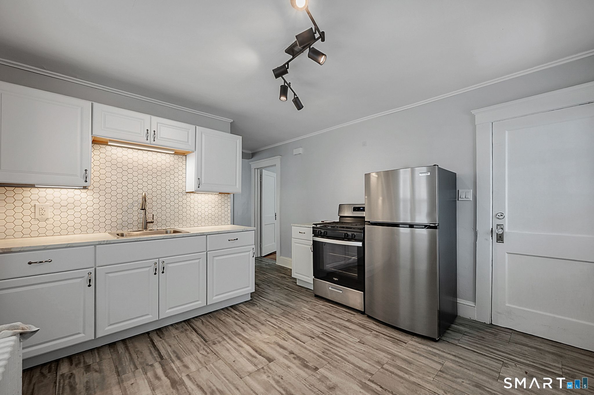 64 Cooper Street Torrington, CT 06790 - Photo 6 of 26 a kitchen with stainless steel appliances a refrigerator sink and wooden floor