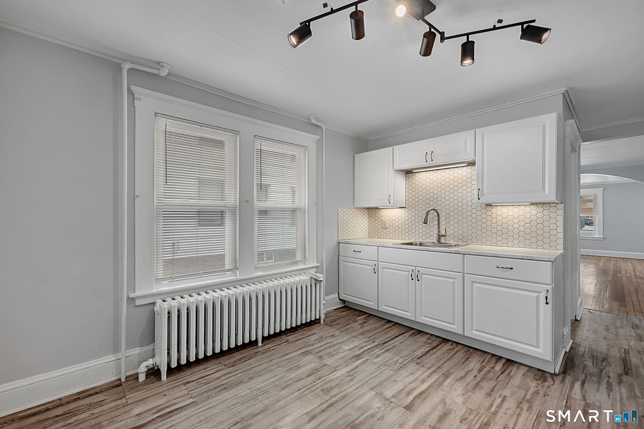 64 Cooper Street Torrington, CT 06790 - Photo 7 of 26 a kitchen with white cabinets and wooden floor
