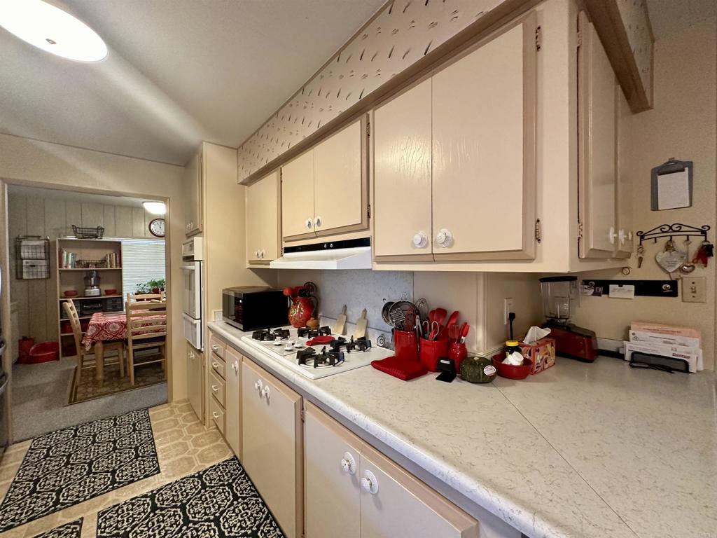 8301 Mission Gorge Road, Unit 194 Santee, CA 92071 - Photo 6 of 61 a kitchen with stainless steel appliances granite countertop a sink dishwasher stove and cabinets with wooden floor