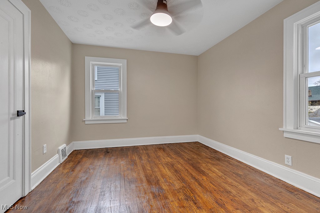 2127 Rossmoor Road Cleveland Heights, OH 44118 - Photo 14 of 21 Empty room with baseboards, ceiling fan, visible vents, and a healthy amount of sunlight