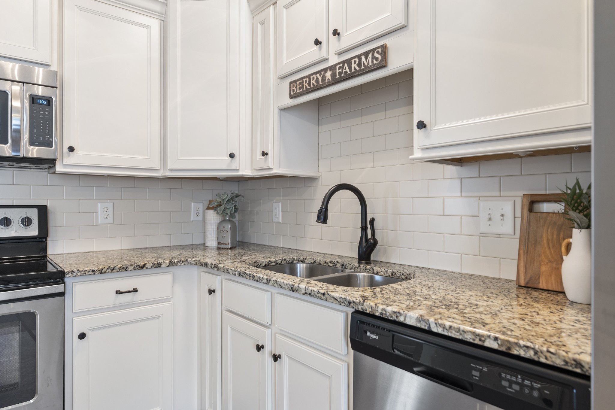 2069 Rural Plains Circle Franklin, TN 37064 - Photo 8 of 74 a kitchen with granite countertop a sink stainless steel appliances white cabinets and a wooden floor