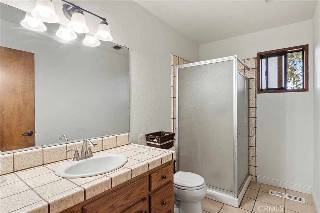 14177 Racine Circle Magalia, CA 95954 - Photo 16 of 52 a bathroom with a granite countertop sink toilet and a mirror