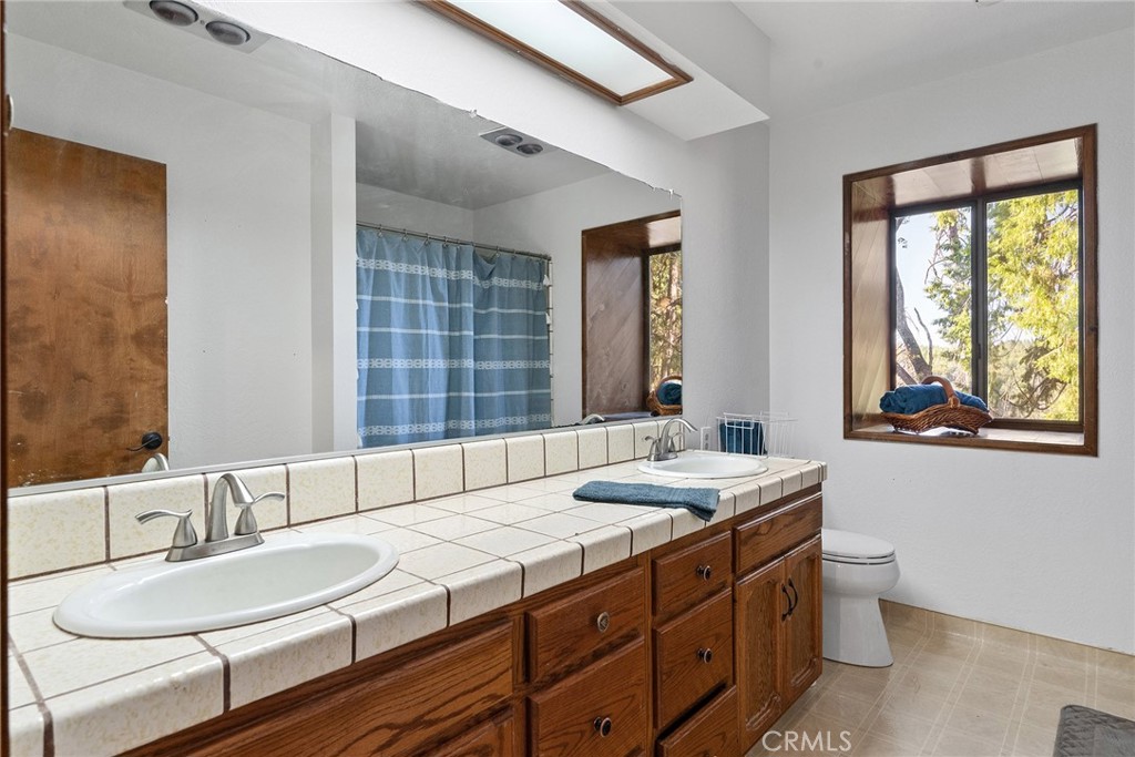 14177 Racine Circle Magalia, CA 95954 - Photo 33 of 52 a bathroom with a granite countertop sink and a large mirror