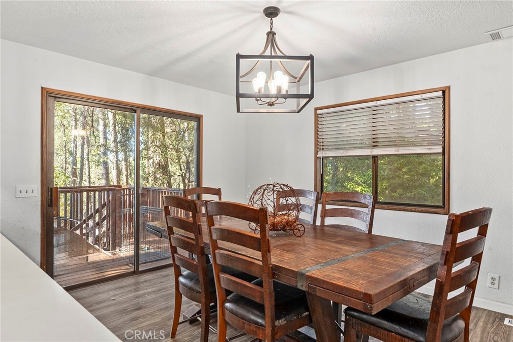 14177 Racine Circle Magalia, CA 95954 - Photo 10 of 52 a dining room with furniture a chandelier and wooden floor