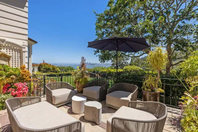 a view of a house with a chairs and table in a patio