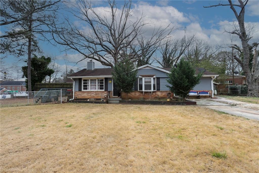 a front view of house with yard and trees around
