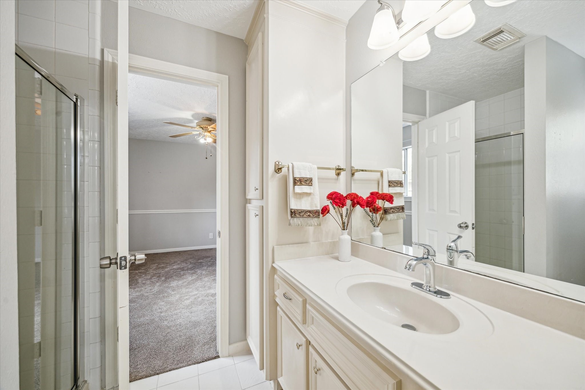 15314 Ripplewind Lane Houston, TX 77068 - Photo 19 of 24 a bathroom with a shower sink vanity and mirror
