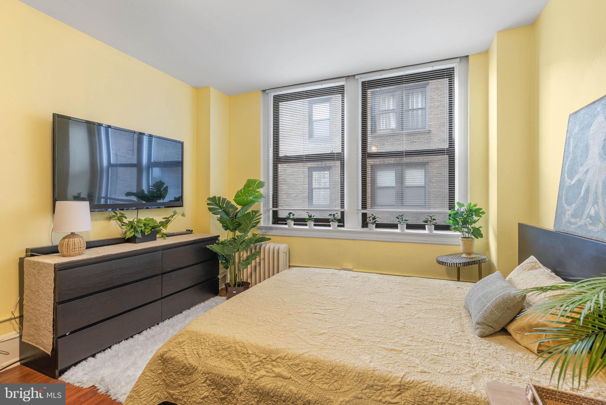 1324 Locust Street, Unit 703 Philadelphia, PA 19107 - Photo 4 of 14 a bedroom with a bed and large windows