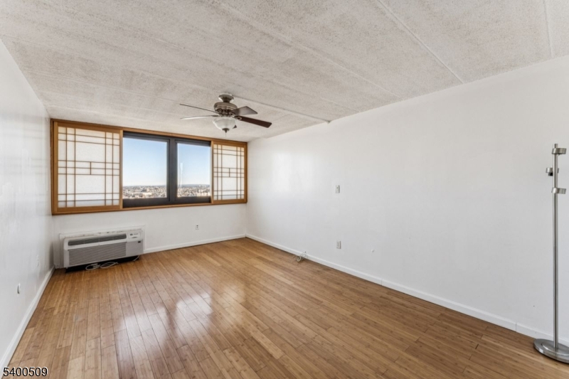 170 Lafayette Avenue, Unit 11E Passaic, NJ 07055 - Photo 14 of 32 an empty room with wooden floor and windows