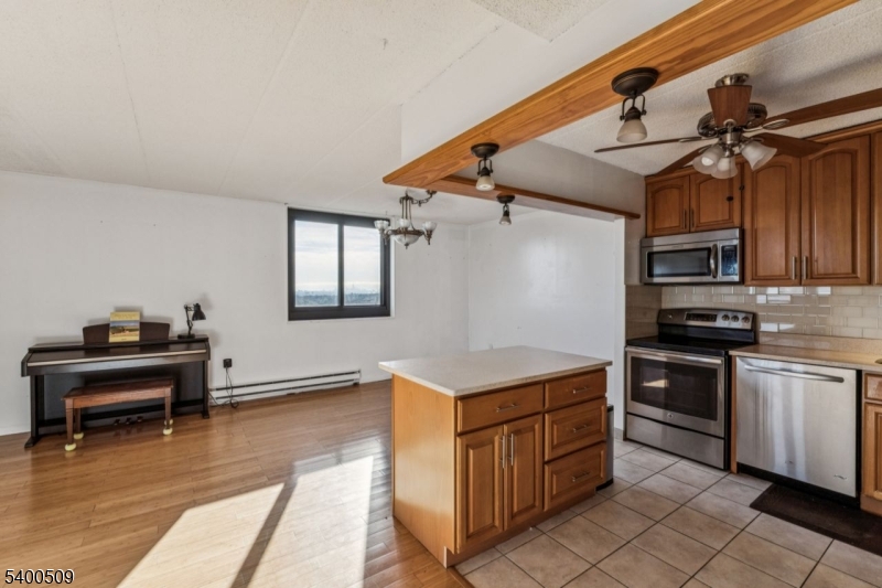 170 Lafayette Avenue, Unit 11E Passaic, NJ 07055 - Photo 9 of 32 a kitchen with cabinets and wooden floor