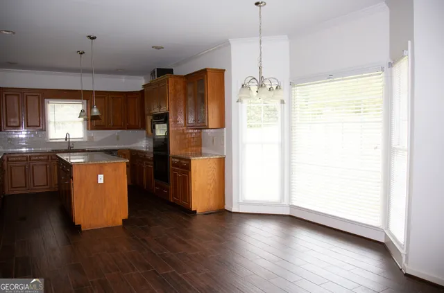 a kitchen with granite countertop wooden cabinets and a stove top oven