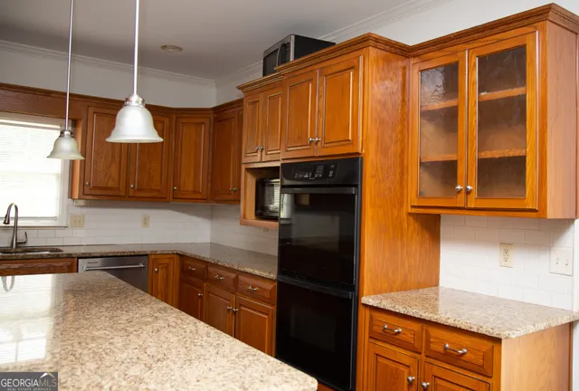 a kitchen with granite countertop wooden cabinets and a sink