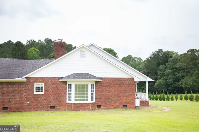 a front view of house with yard and trees in the background