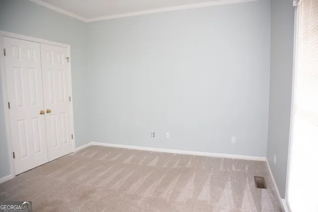 an empty room with a ceiling fan and window