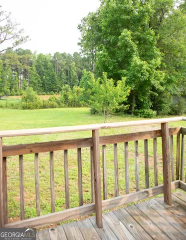 a view of a wooden balcony with a yard
