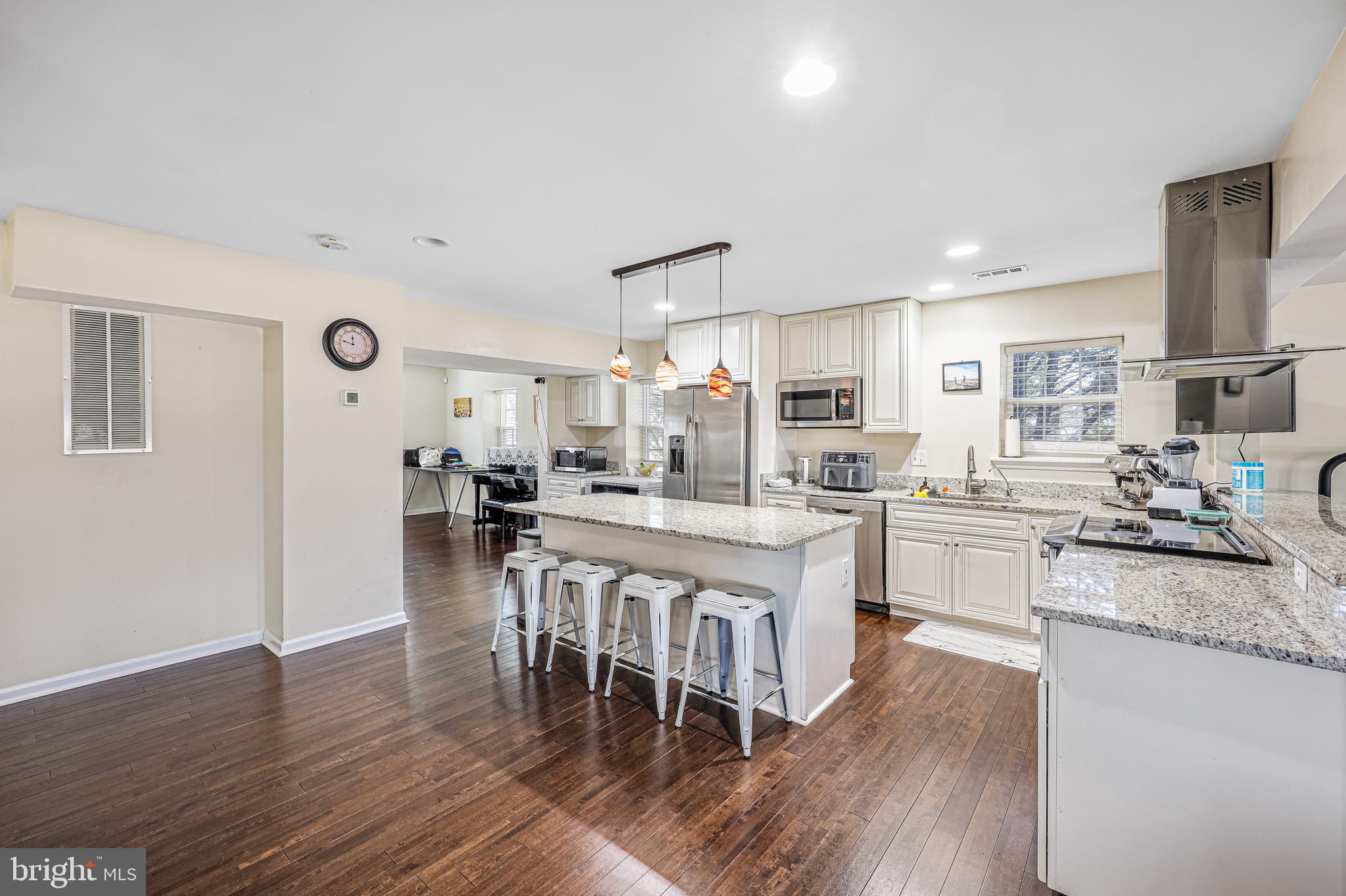 14816 Bushy Park Road Woodbine, MD 21797 - Photo 5 of 40 a kitchen with stainless steel appliances granite countertop a stove top oven a sink a refrigerator white cabinets and wooden floor
