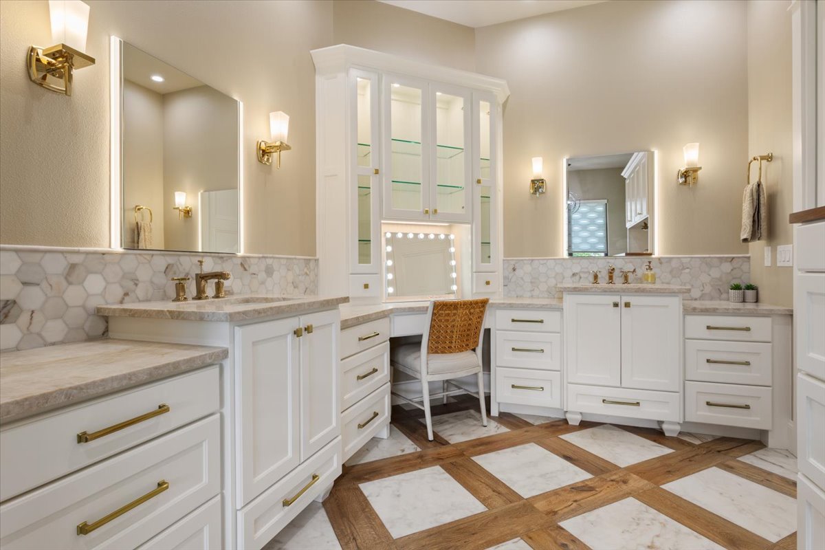 309 Highland Spring Lane Georgetown, TX 78633 - Photo 22 of 40 Have you seen a more elegant Primary Bathroom? Separate dual vanities with counter space for each. Also lighted mirror for each sink. Lighted make-up mirror with the makeup vanity & lighted glass front cabinets for your collectibles. Flooring is marble tile and wood...