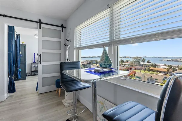 a room with a chair and a large window with wooden floor