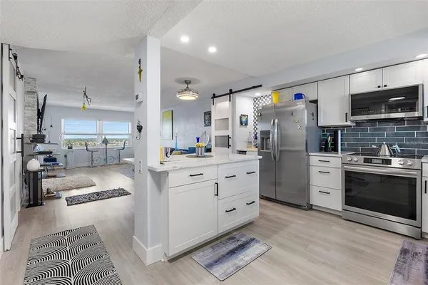 a kitchen with white cabinets and stainless steel appliances