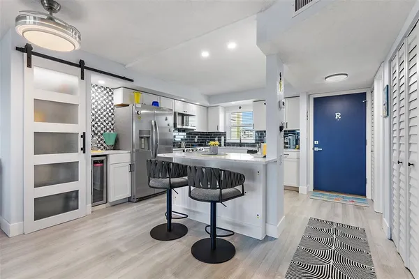 a kitchen with stainless steel appliances granite countertop a refrigerator and a stove top oven
