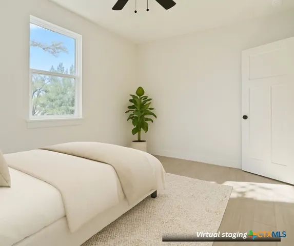 a bedroom with a bed and a potted plant