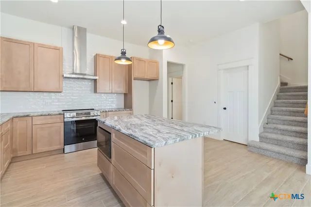 a kitchen with a stove and a wooden floor