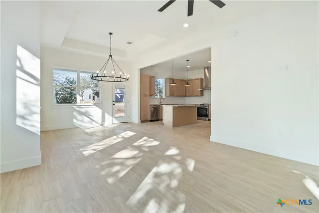 a kitchen with kitchen island granite countertop a sink cabinets and stainless steel appliances